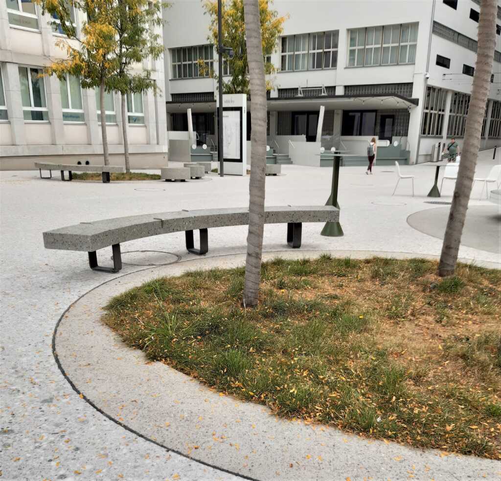 Eine Sitzbank vor einem Kreis mit einer Wiese und Bäumen vor dem SihlCity.